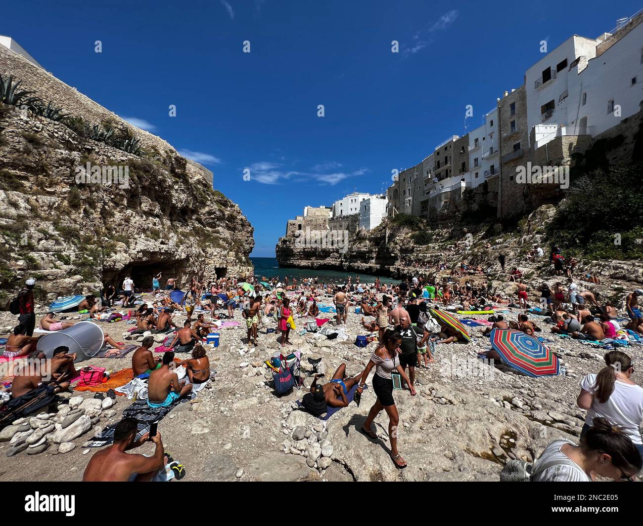 I bagnanti possono godersi la spiaggia di Lido Cala Paura a Polignano a Mare. Circondato da scogliere drammatiche e acque cristalline del Mare Adriatico, è Foto Stock