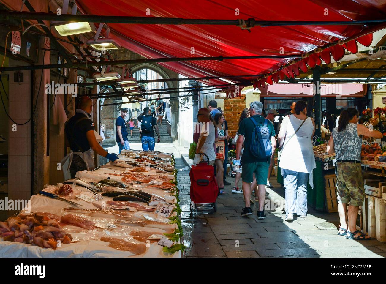 Le persone che acquistano il pescato del giorno presso una bancarella del mercato di Rialto in piazza campo della Pescaria, sestiere di San Polo, Venezia, Veneto, Italia Foto Stock