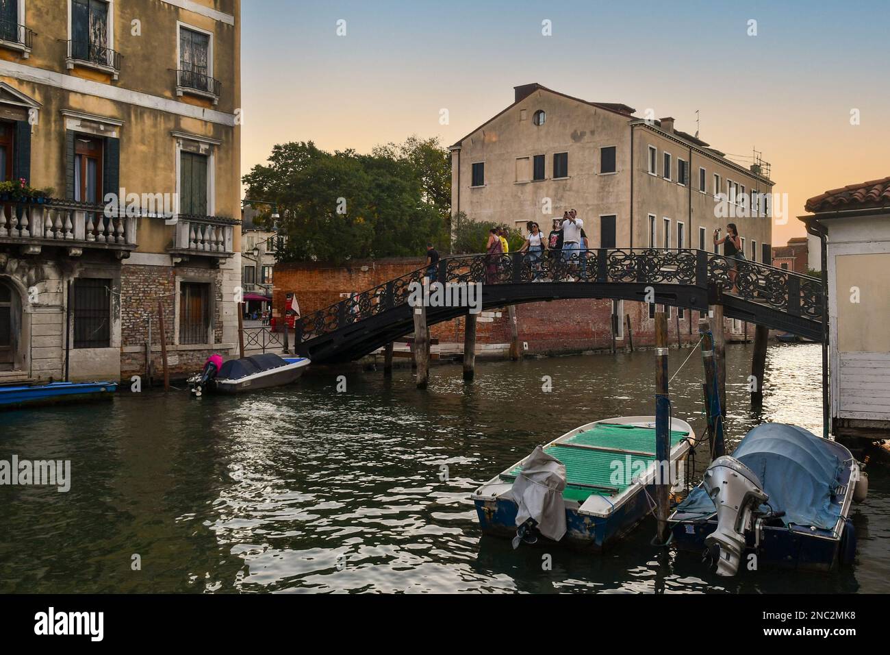 Ponte de Gheto Novo sul Rio della Misericordia nel sestiere di Cannaregio con gente al tramonto, Venezia, Veneto, Italia Foto Stock