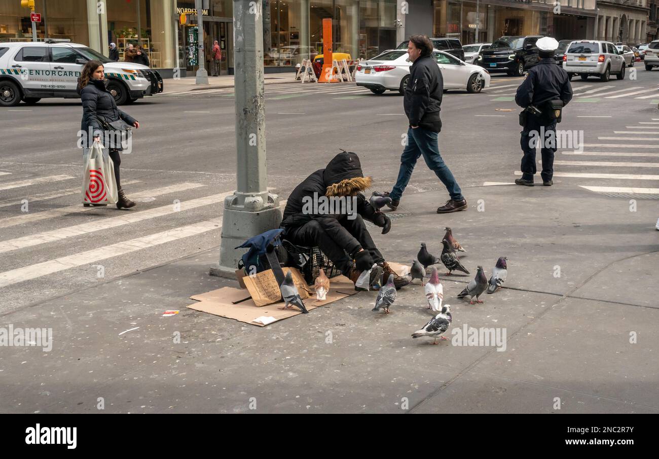 I senzatetto nutrono i piccioni a Midtown Manhattan a New York domenica 5 febbraio 2023. (© Richard B. Levine) Foto Stock