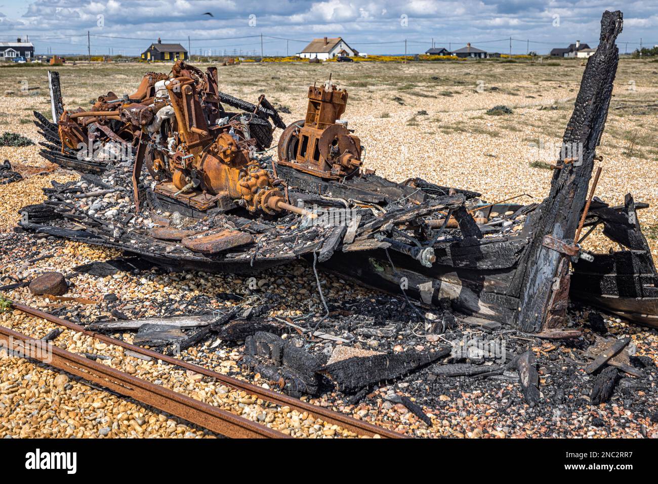 Resti di una vecchia barca di legno bruciato, Dungeness, Kent, Inghilterra Foto Stock