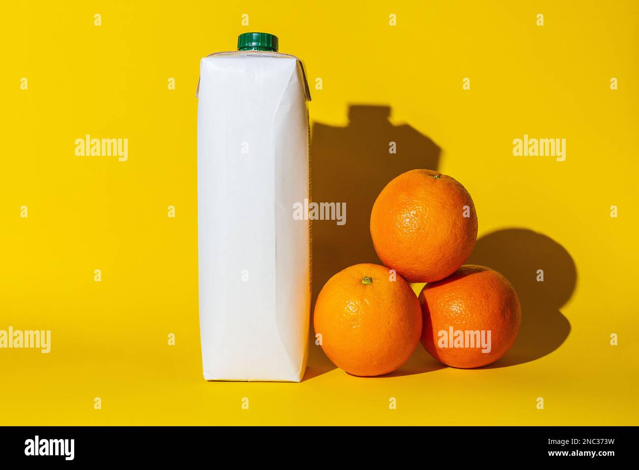 pacchetto succo vuoto copia spazio arance, succo d'arancia per bere, diversi oggetti, ombra dura, bianco cartone arance colore, giacciono sulla superficie della y Foto Stock