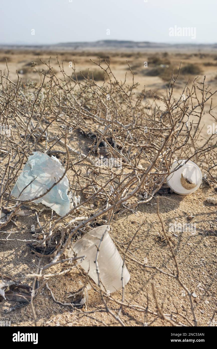 Rifiuti di plastica su una duna di sabbia, fuoco selettivo. Foto Stock