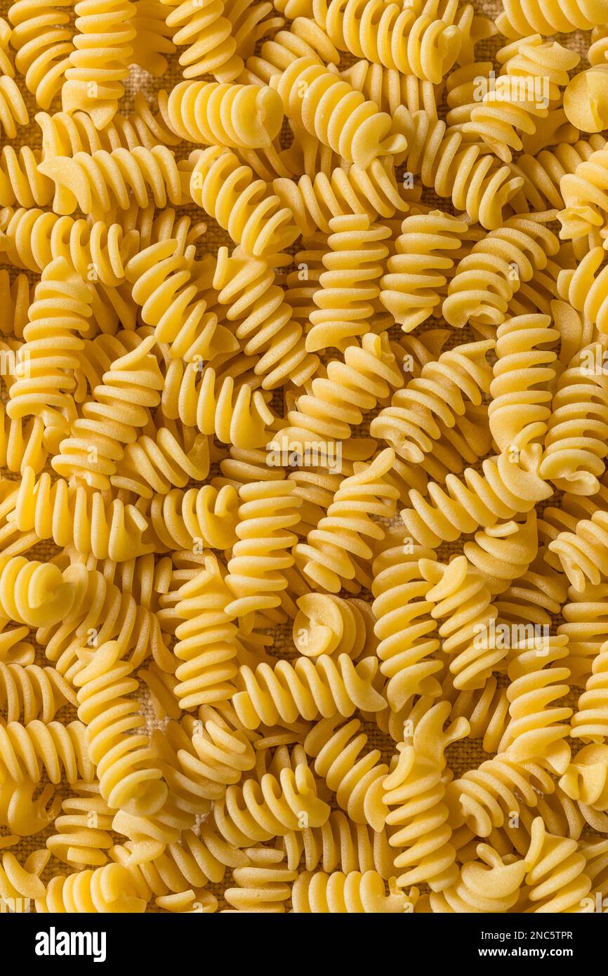 Pasta secca di Fusilli biologica cruda in una ciotola Foto Stock
