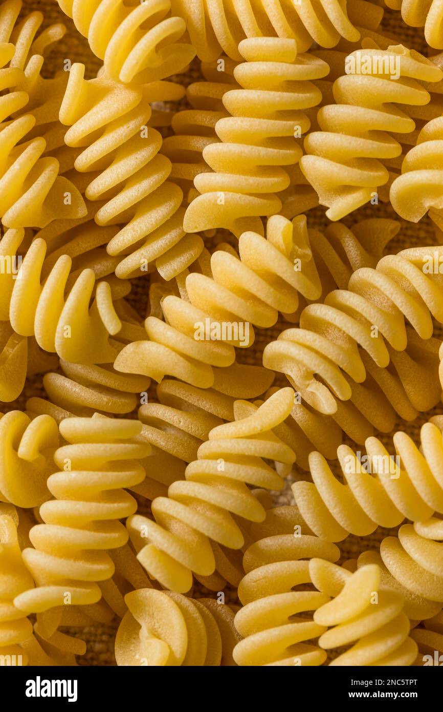 Pasta secca di Fusilli biologica cruda in una ciotola Foto Stock