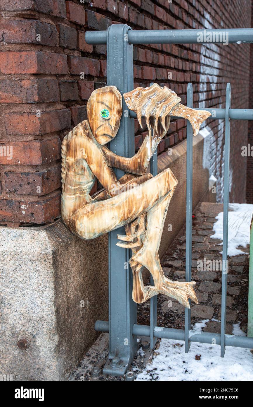 Street art. Piccola scultura in legno o rilievo sulla recinzione Keskiputous a Tampere, Finlandia. Foto Stock