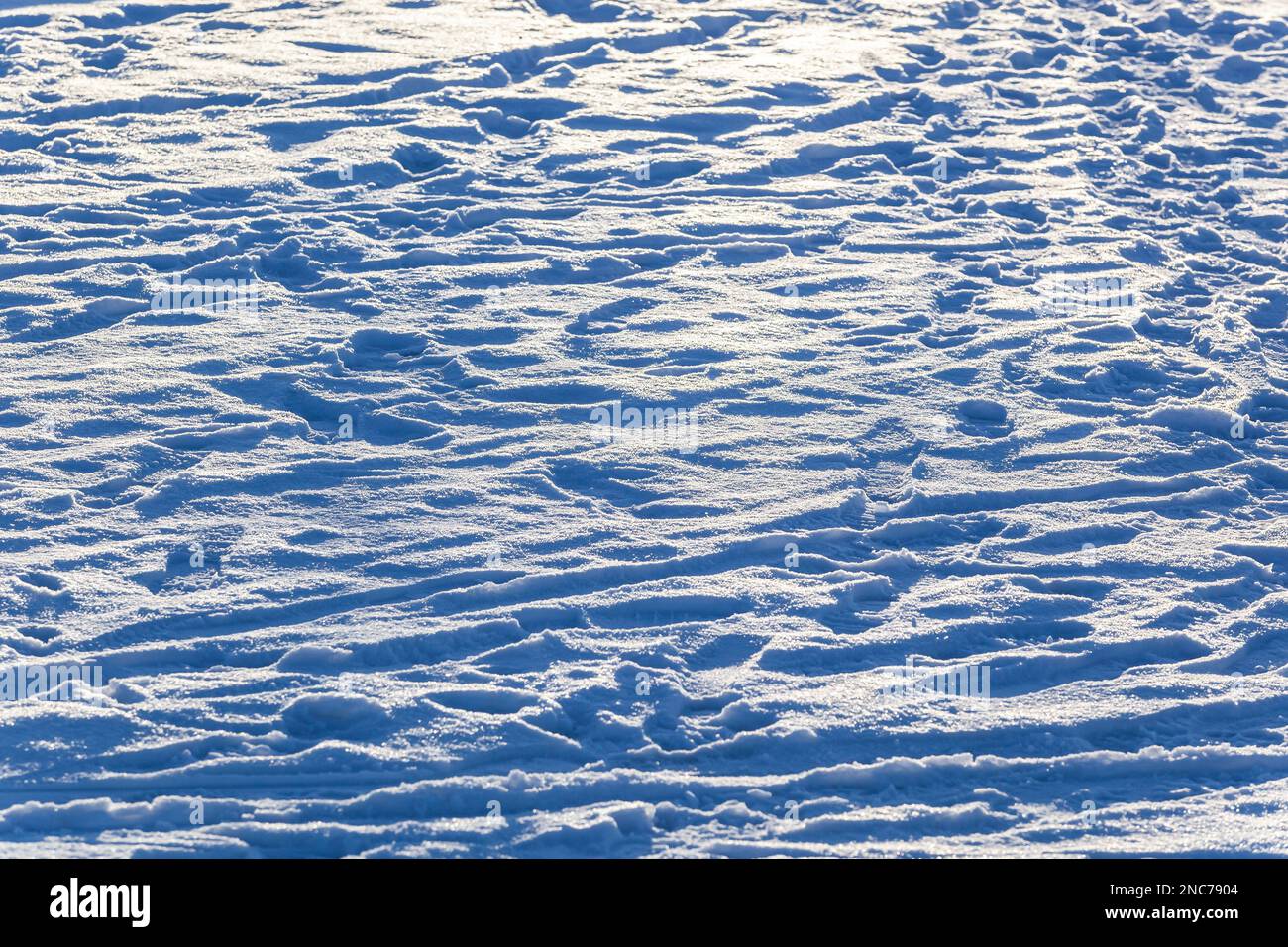 Tracce sulla neve bianca alla luce del sole. Trama. Sfondo. Orizzontale. Foto di alta qualità. Foto Stock
