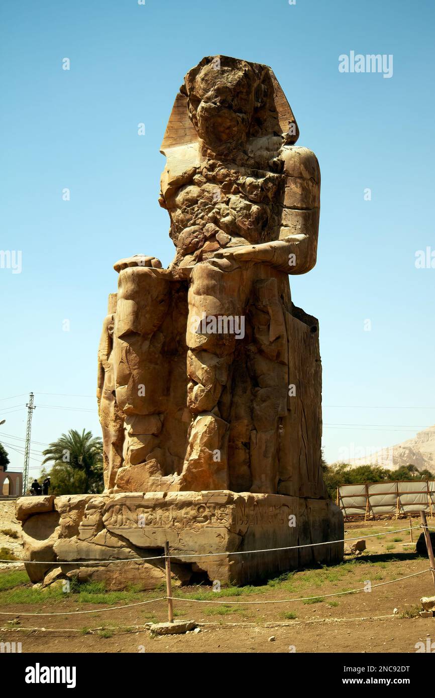 Luxor, Egitto. I Colossi di Memnon sono due massicce statue in pietra del faraone Amenhotep III, che si trovano di fronte al tempio mortuario rovinato Foto Stock