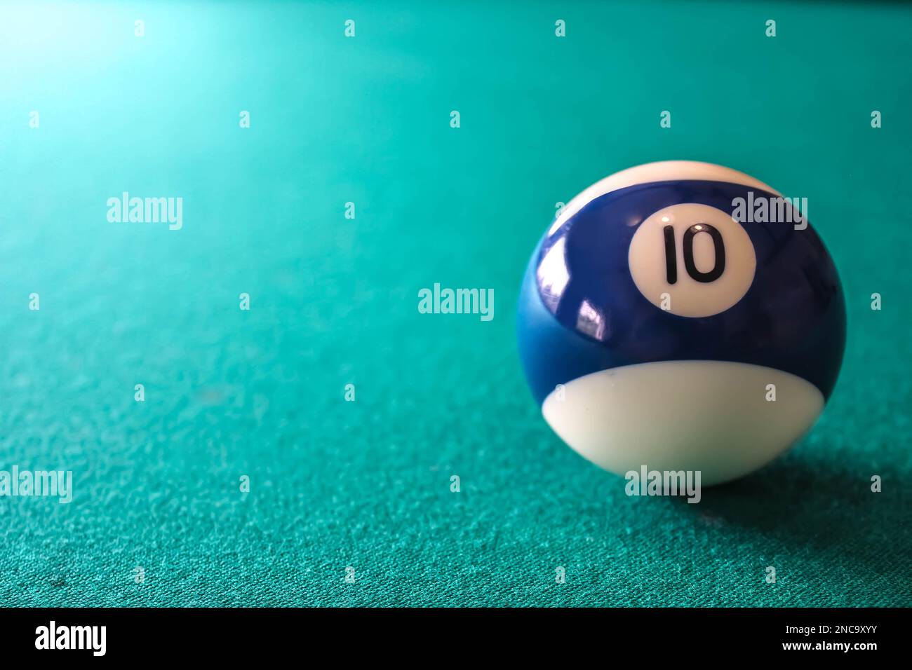 Pallina da biliardo bianca e blu a righe con numero 10 su sfondo verde con copia per testo o disegno. Foto Stock
