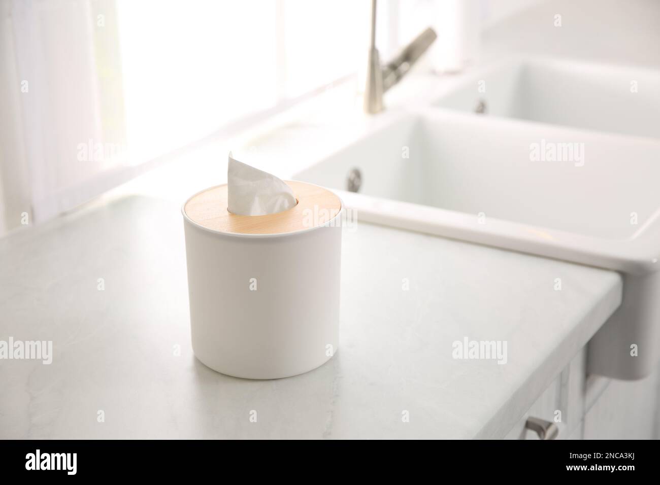 Scatola con fazzolettini di carta sul banco bianco in cucina Foto Stock