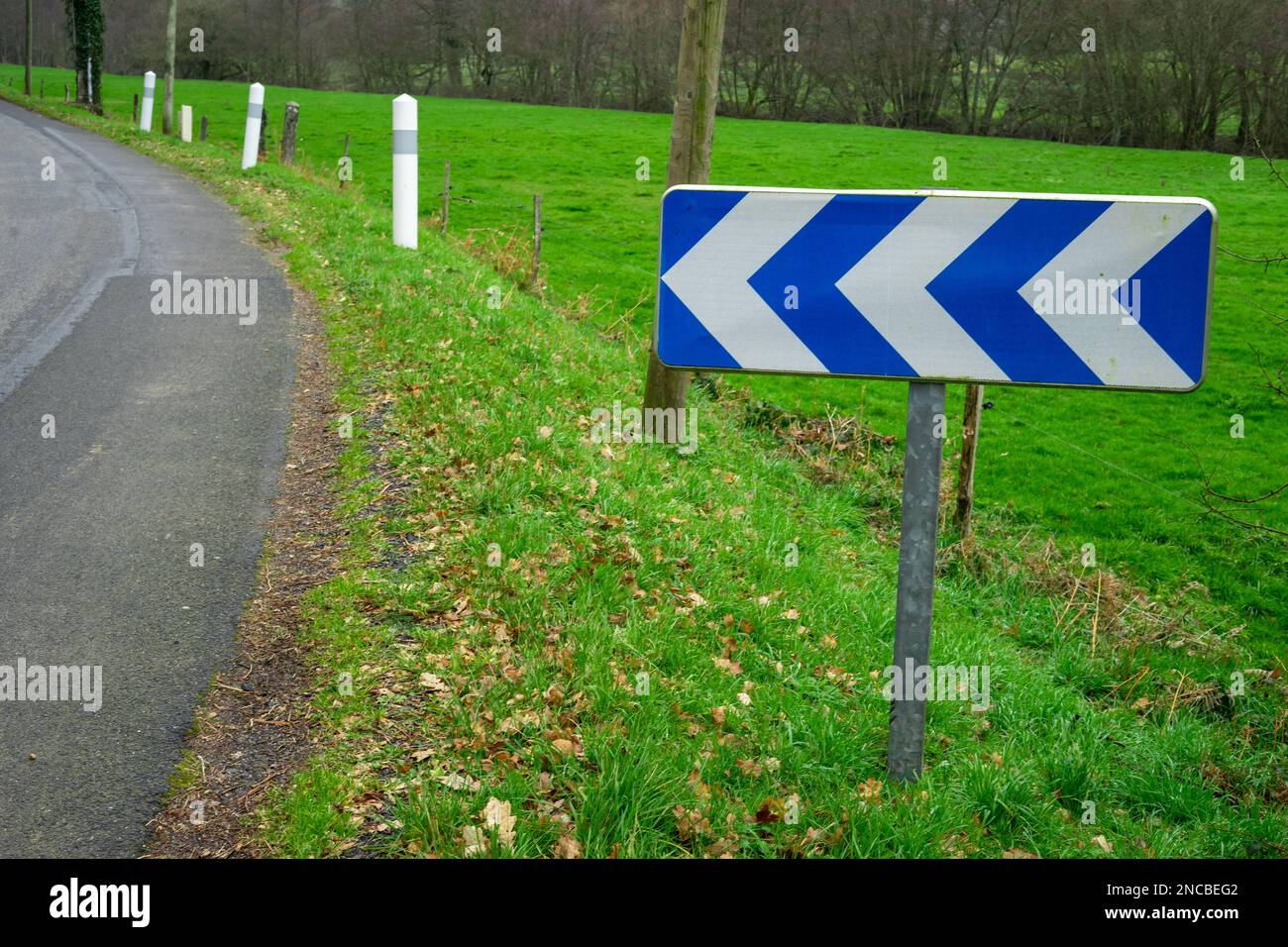 Segnalazione di una svolta sulla strada e di un segnale stradale. Concetto di sicurezza stradale. Una freccia indica una svolta a sinistra sulla strada. Foto Stock