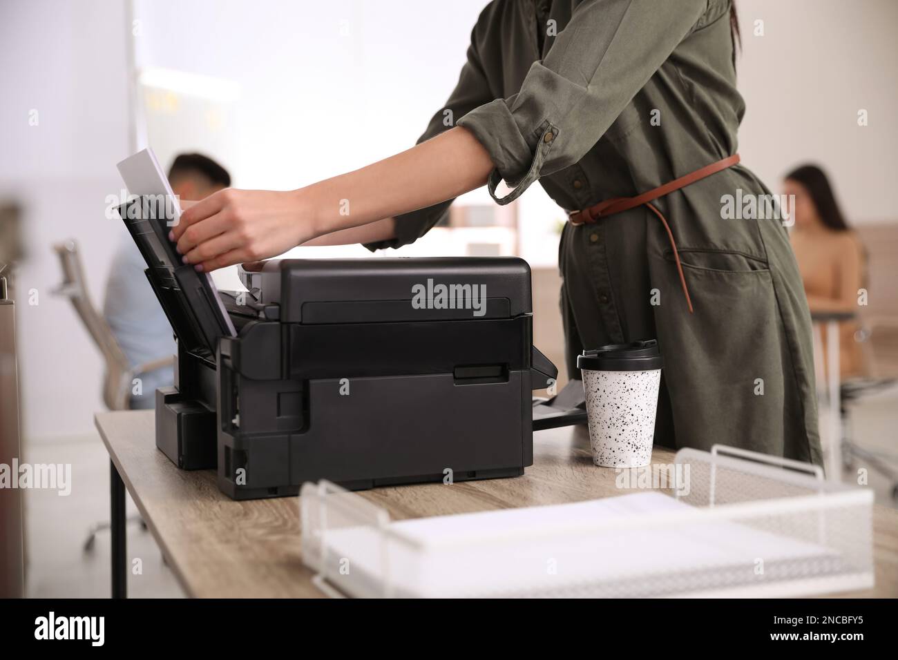 Dipendente che utilizza una stampante moderna in ufficio, in primo piano Foto Stock