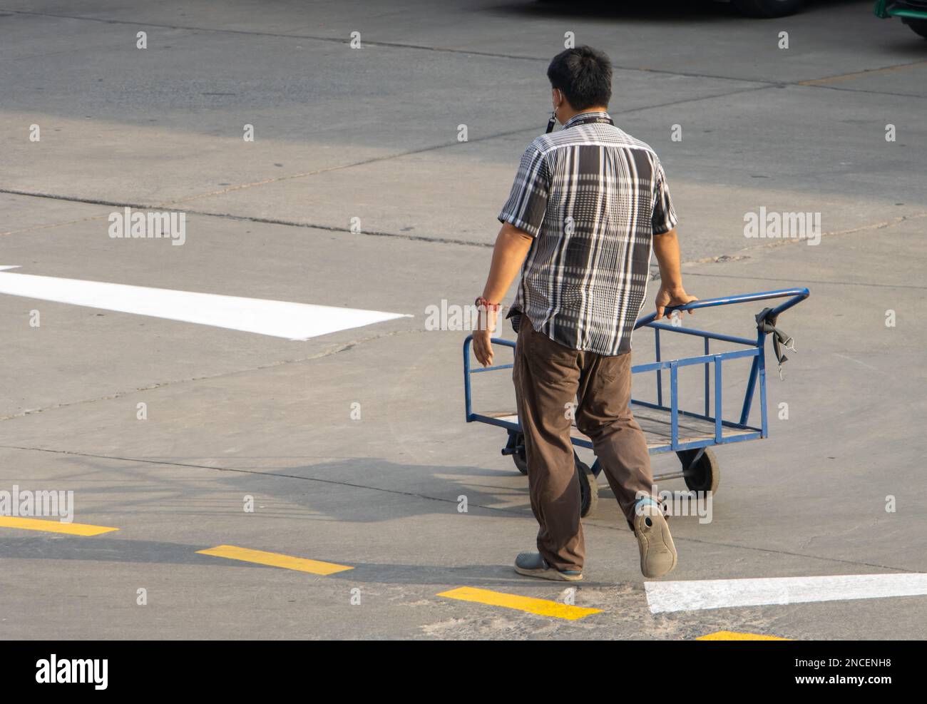SAMUT PRAKAN, THAILANDIA, 30 2023 GENNAIO, Un uomo spinge un carrello vuoto a tre ruote sulla strada Foto Stock