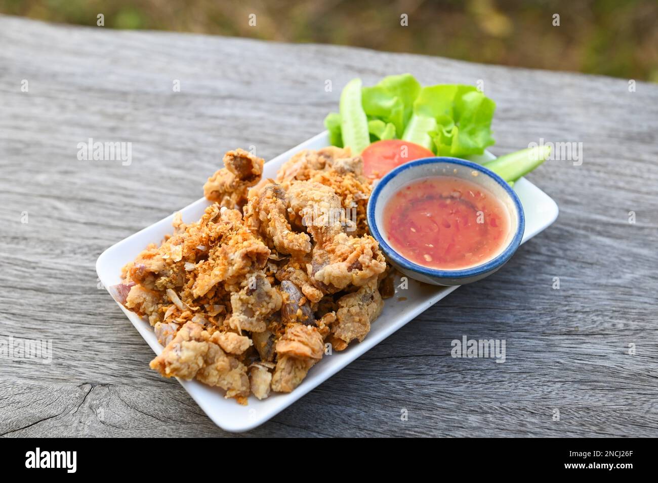 Intestino di maiale fritto con aglio con salsa sul piatto - frattaglie di maiale cibo tailandese o snack Foto Stock