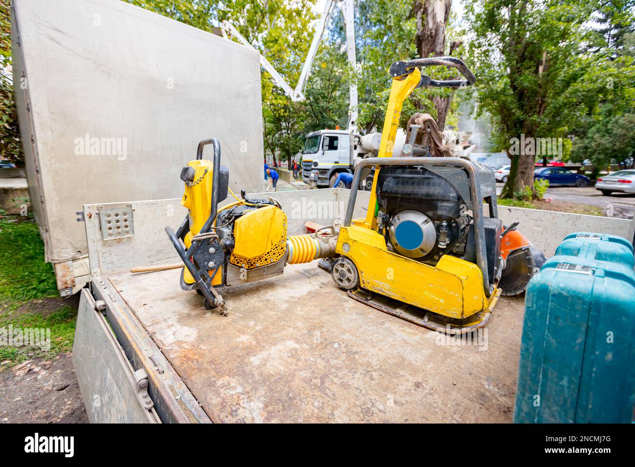 Compattatore a piastre piccole, martello vibrante in posizione eretta e macchina compattatrice con martinetto a salto è stata posizionata sul rimorchio dell'autocarro. Utensili elettrici in cantiere. Foto Stock