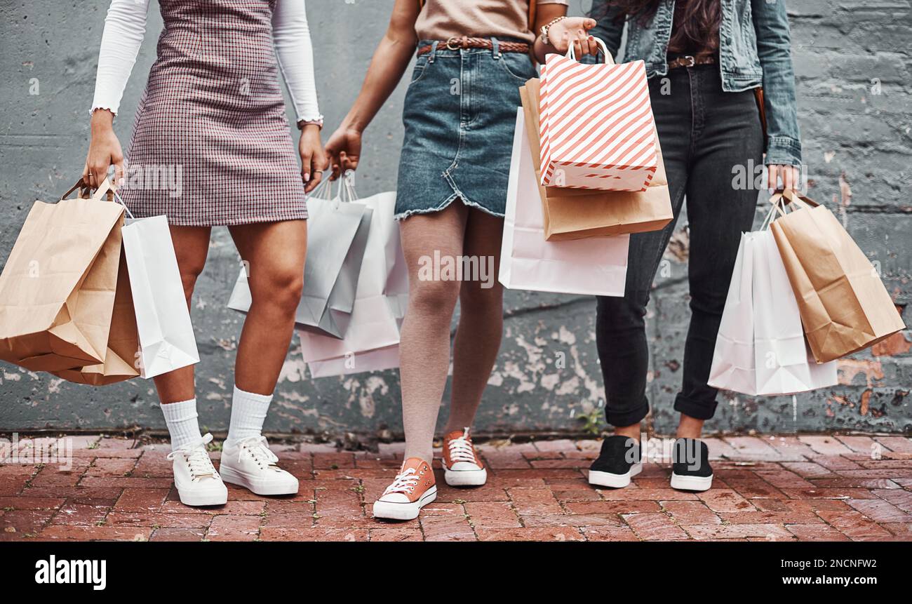 Fai shopping fino a quando non ne hai più. un gruppo irriconoscibile di sorelle in piedi insieme alle loro borse per lo shopping durante una giornata in città. Foto Stock