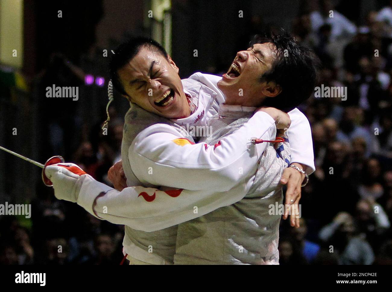 China's Lei Sheng, right, celebrates with an unidentified teammate after China defeated Italy in the men's foil team final during the fencing World Championships, Thursday Nov. 11, 2010 in Paris. (AP Photo/Francois Mori) Foto Stock