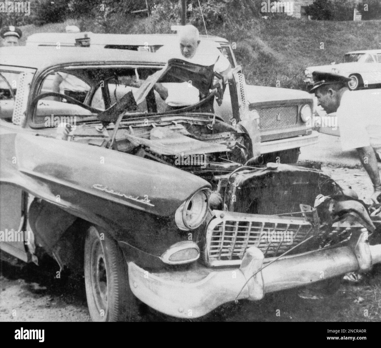 Officers are shown examining the damage to the auto of Metcalf