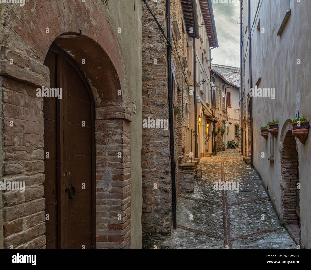 Scorci di vicoli, palazzi, archi e gradini della città medievale in pietra e mattoni del comune di Contigliano. Contigliano, Lazio Foto Stock