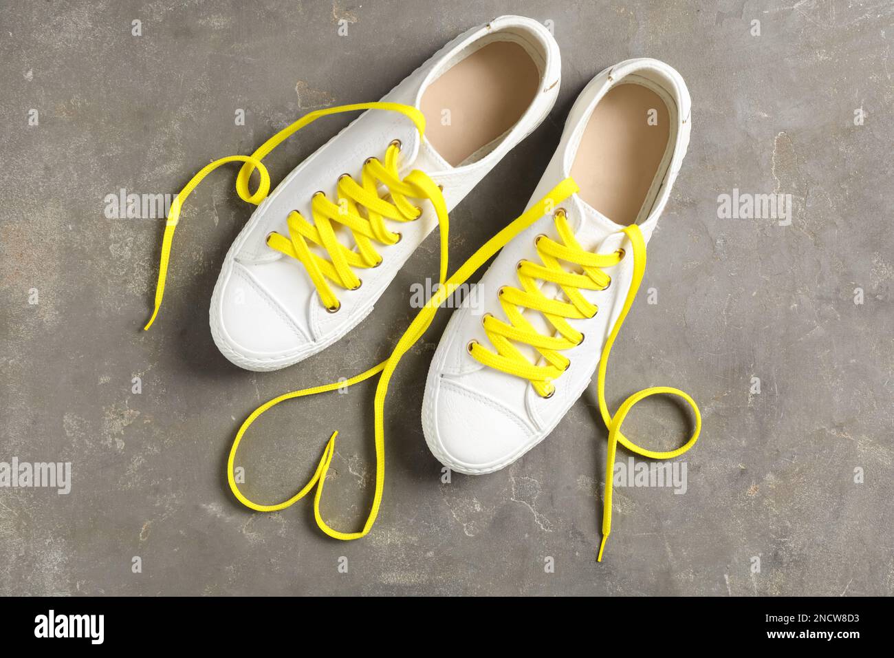 Paio di scarpe eleganti con lacci gialli su sfondo grigio, a posa piatta Foto Stock