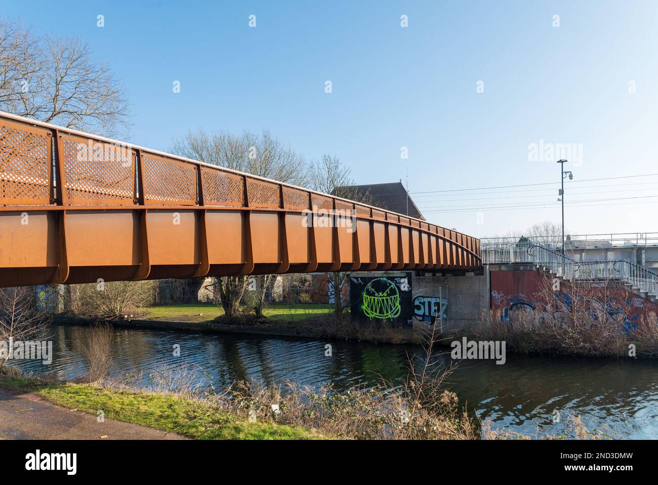 Moderno ponte pedonale color ruggine che attraversa il canale Worcester e Birmingham a Selly Oak, Birmingham Foto Stock