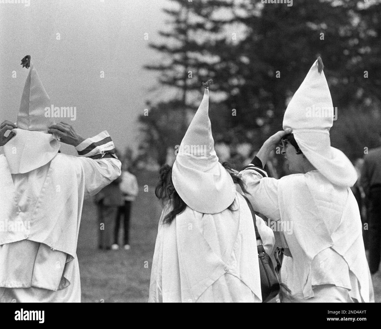 There were about 300 people in all in attendance, about 50 to 60 robed Klansman-men, women, and children. Robert M. Shelton, Imperial Wizzard from Alabama, was the main speaker. An idea for a picture layout might be to show the different Klansman. Wives and lovers, husbands and oldsters etc., in an undated photo. Seven white horsemen came riding in to the meeting. They stopped and allowed some pictures to be taken. About 9:30 the ceremony at the cross began. The walking Klansmen circled the cross. They lit the torches and started walking around the cross singing while they walked. The horsemen Foto Stock