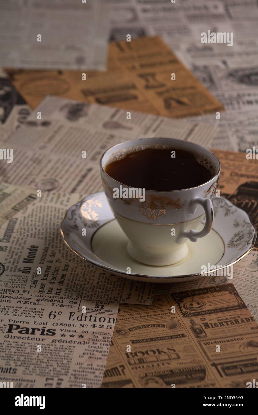foto di una tazza di caffè su un tavolo fatto di ritagli di vecchi giornali Foto Stock