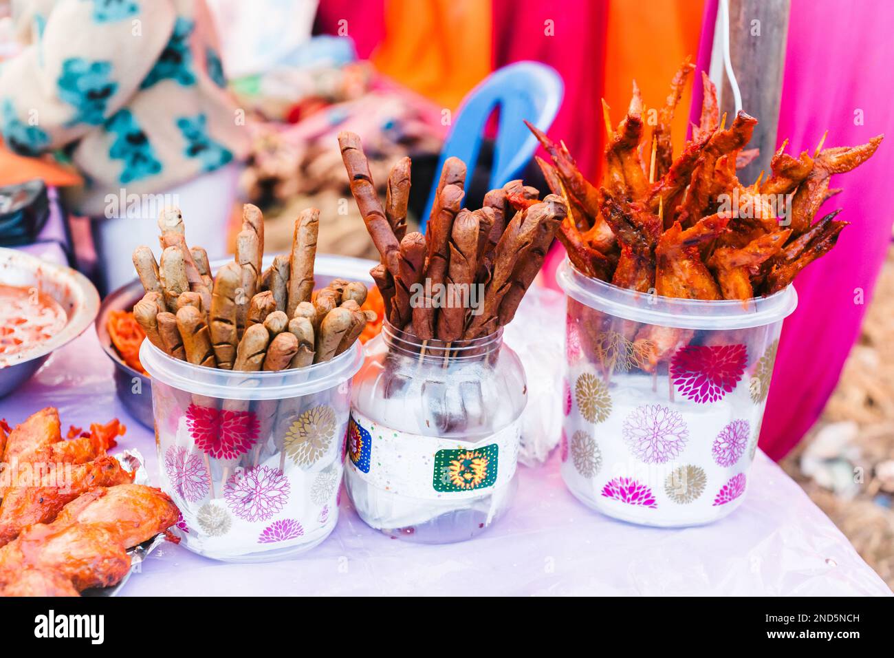 Salsicce fritte di fresco, pesce e piedi di pollo fritti in vendita nel mercato di strada nepalese Foto Stock