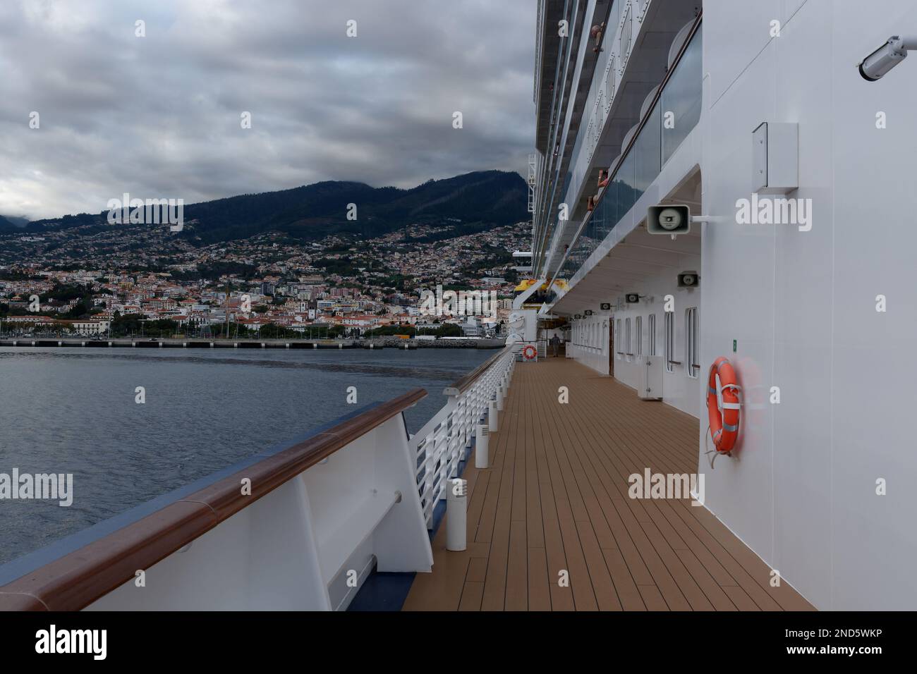 Vista sul ponte di una nave da crociera che parte dal porto di Funchal a Madeira. Una vista sul ponte laterale con Funchal sullo sfondo. Foto Stock