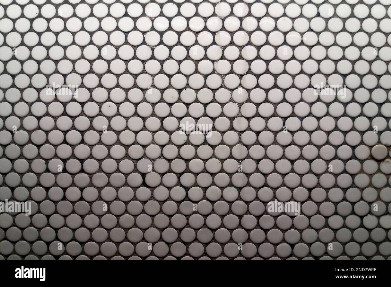 Primo piano sulle piastrelle circolari bianche della metropolitana di Parigi. Foto Stock