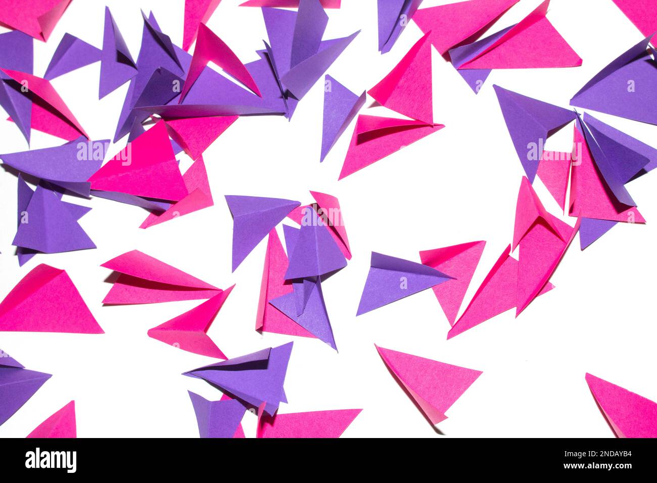 Una forma a triangolo in carta piegata geometrica rosa viola e bianca per l'artigianato dello sfondo Foto Stock