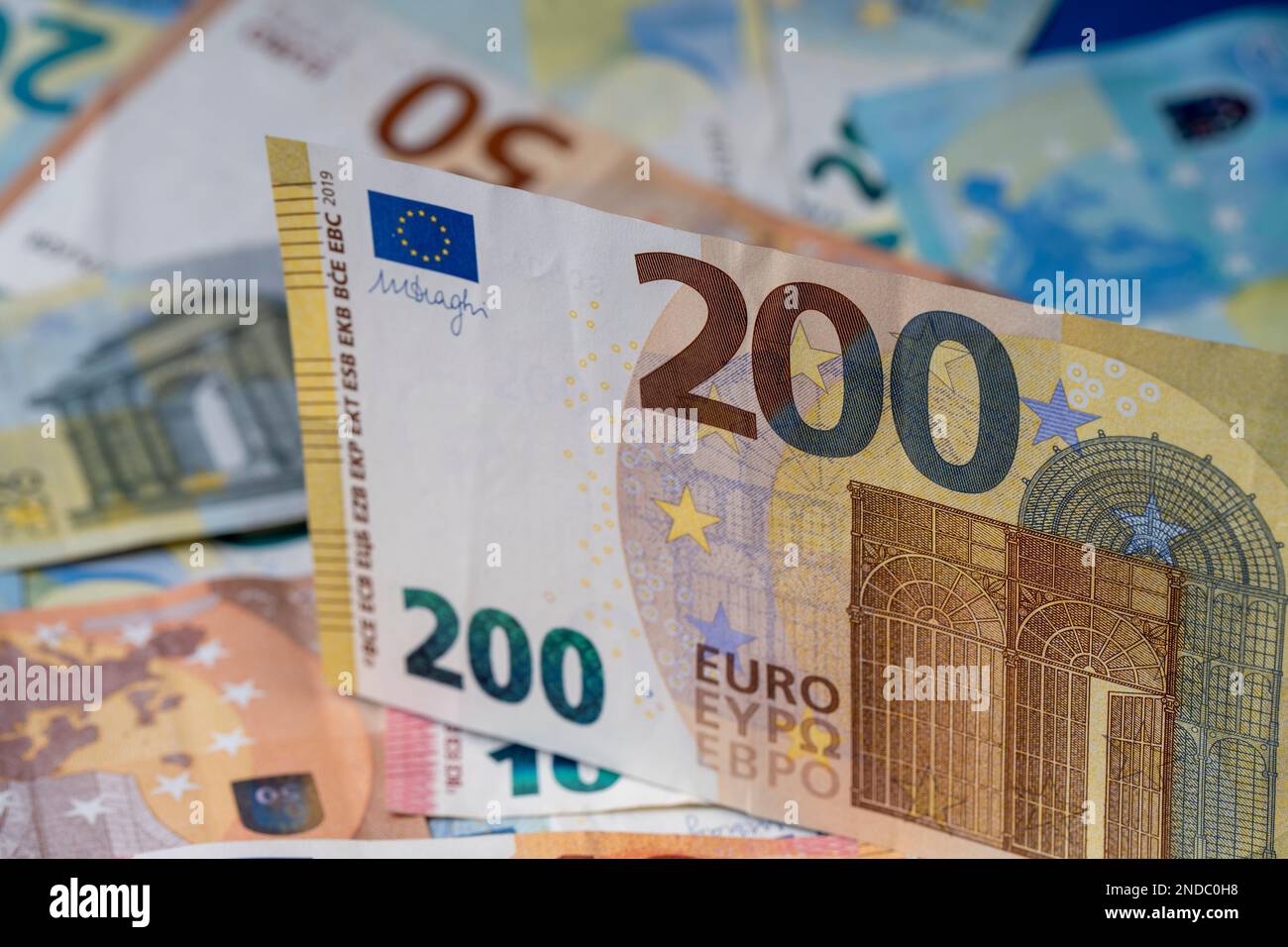 Una pila di banconote sul tavolo. Duecento euro di carta moneta in primo piano. Banconote miste in euro in background. Foto Stock