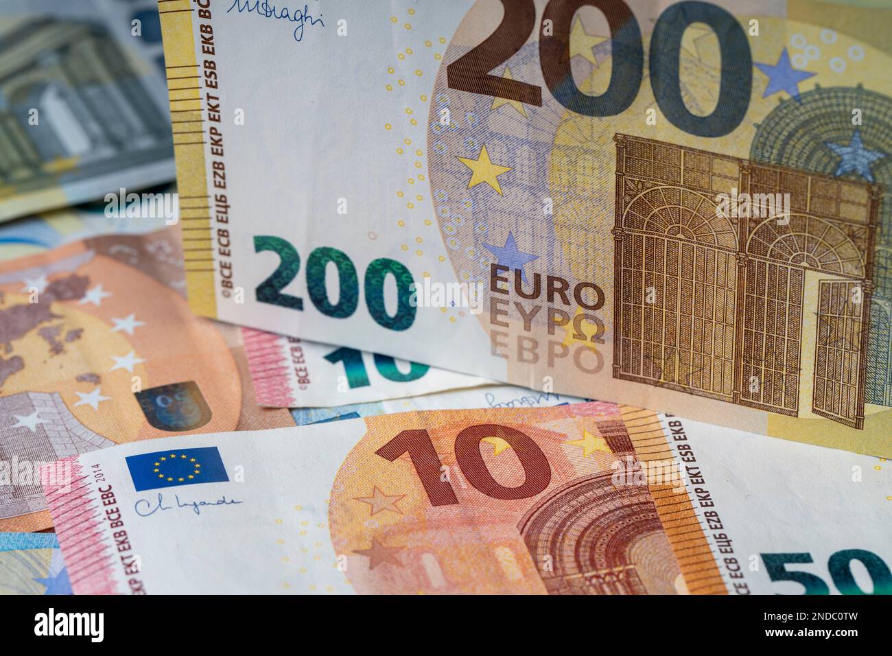 Una pila di banconote sul tavolo. Duecento euro di carta moneta in primo piano. Banconote miste in euro in background. Foto Stock