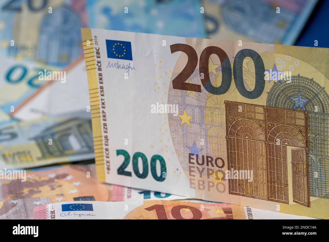 Una pila di banconote sul tavolo. Duecento euro di carta moneta in primo piano. Banconote miste in euro in background. Foto Stock