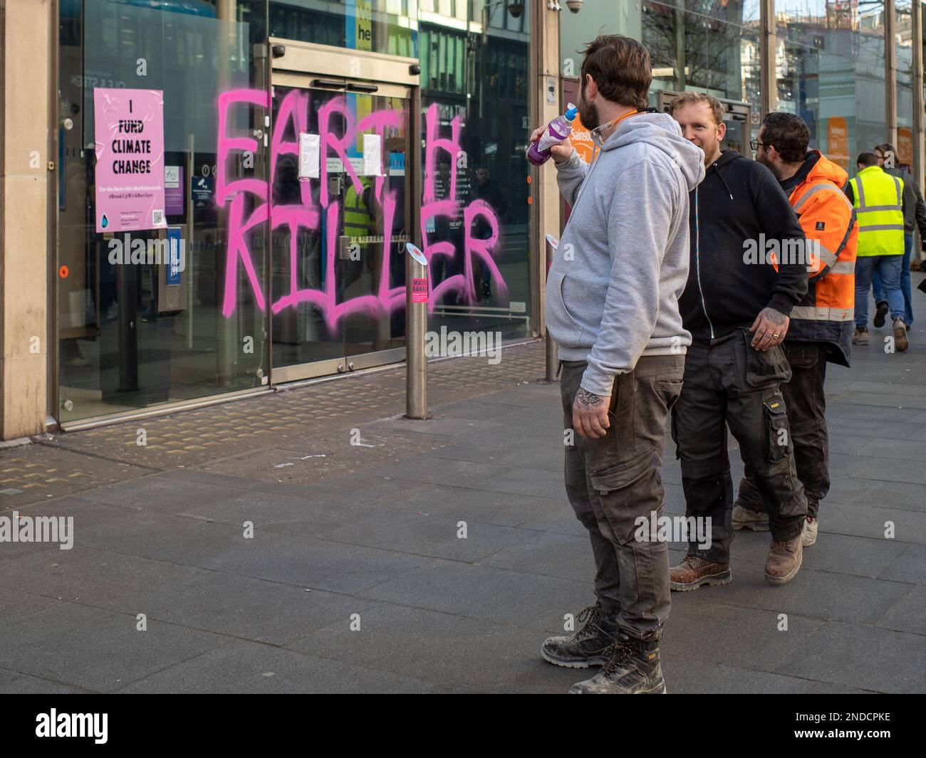 I sostenitori del cambiamento climatico dipingono Graffiti 'Earth Killer' sulla Barclays Bank, filiale di Tottenham Court Road, Londra, febbraio 2023. Ribellione di estinzione. Foto Stock