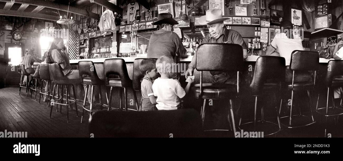 Un anziano che dà una donazione di bollette in dollari a due ragazzi della Sawmill Saloon di Darby, Montana Foto Stock