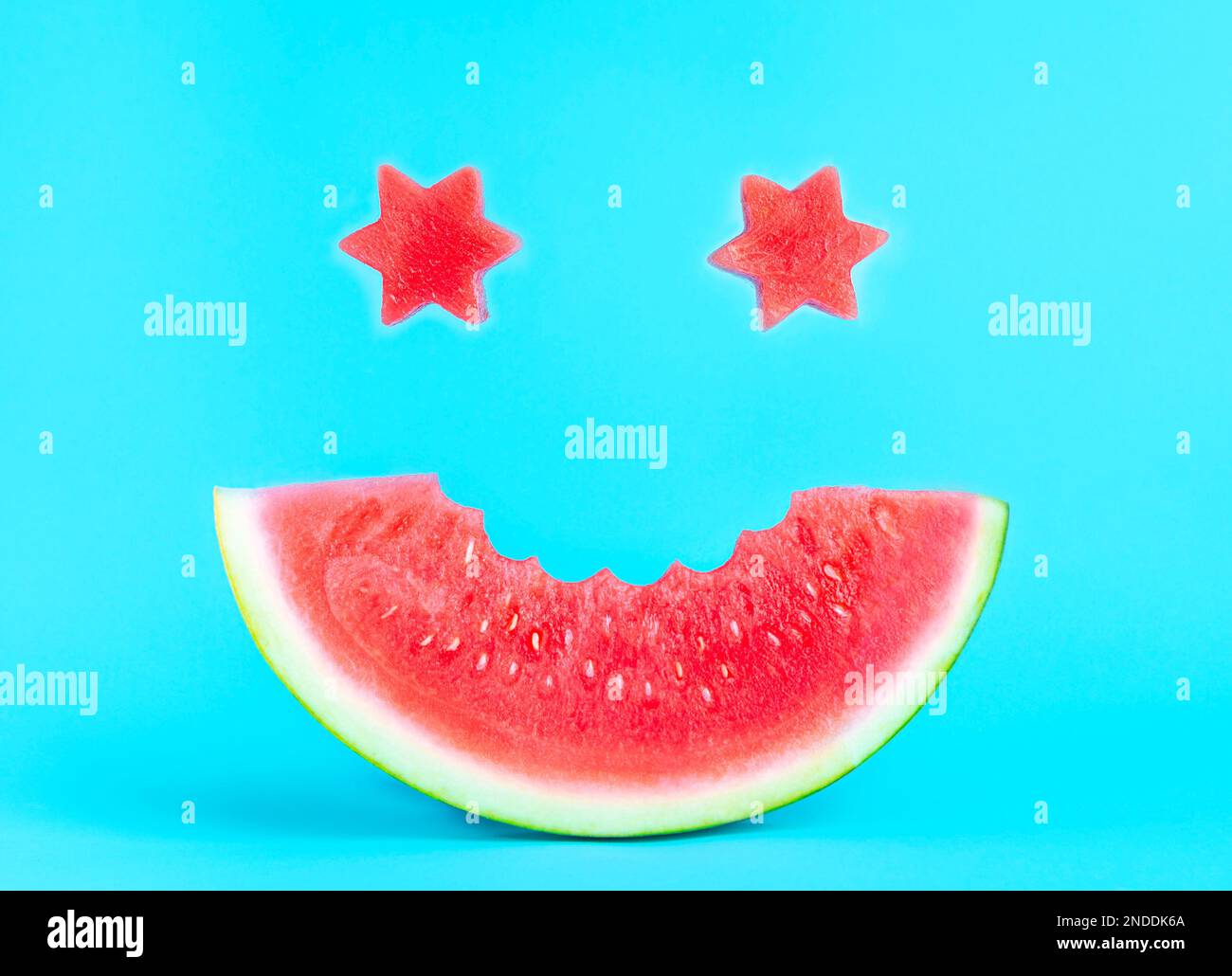 Un sorriso di anguria su sfondo blu, occhi stellari Foto Stock