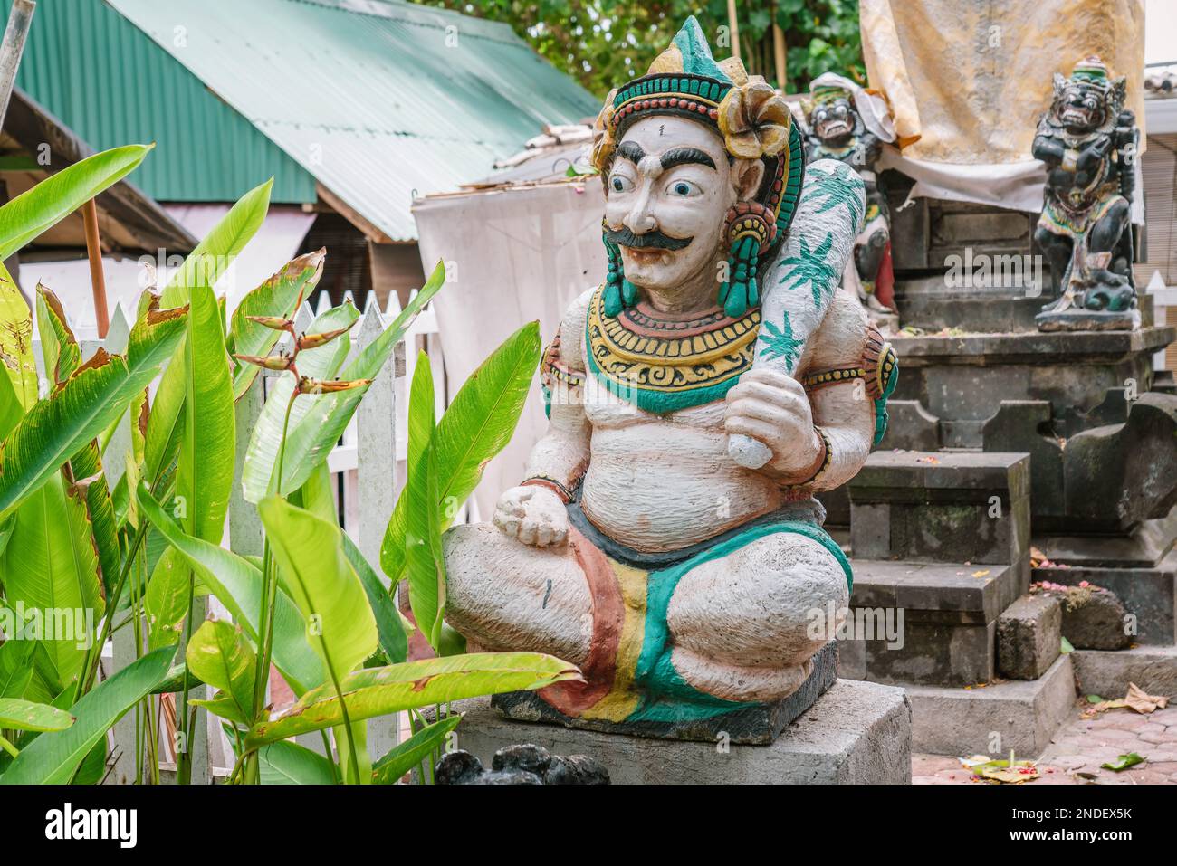Tradizionale statua della guardia balinese di solito collocata nei punti di ingresso a luoghi pubblici o privati. Due statue di guardia sfocate sullo sfondo Foto Stock