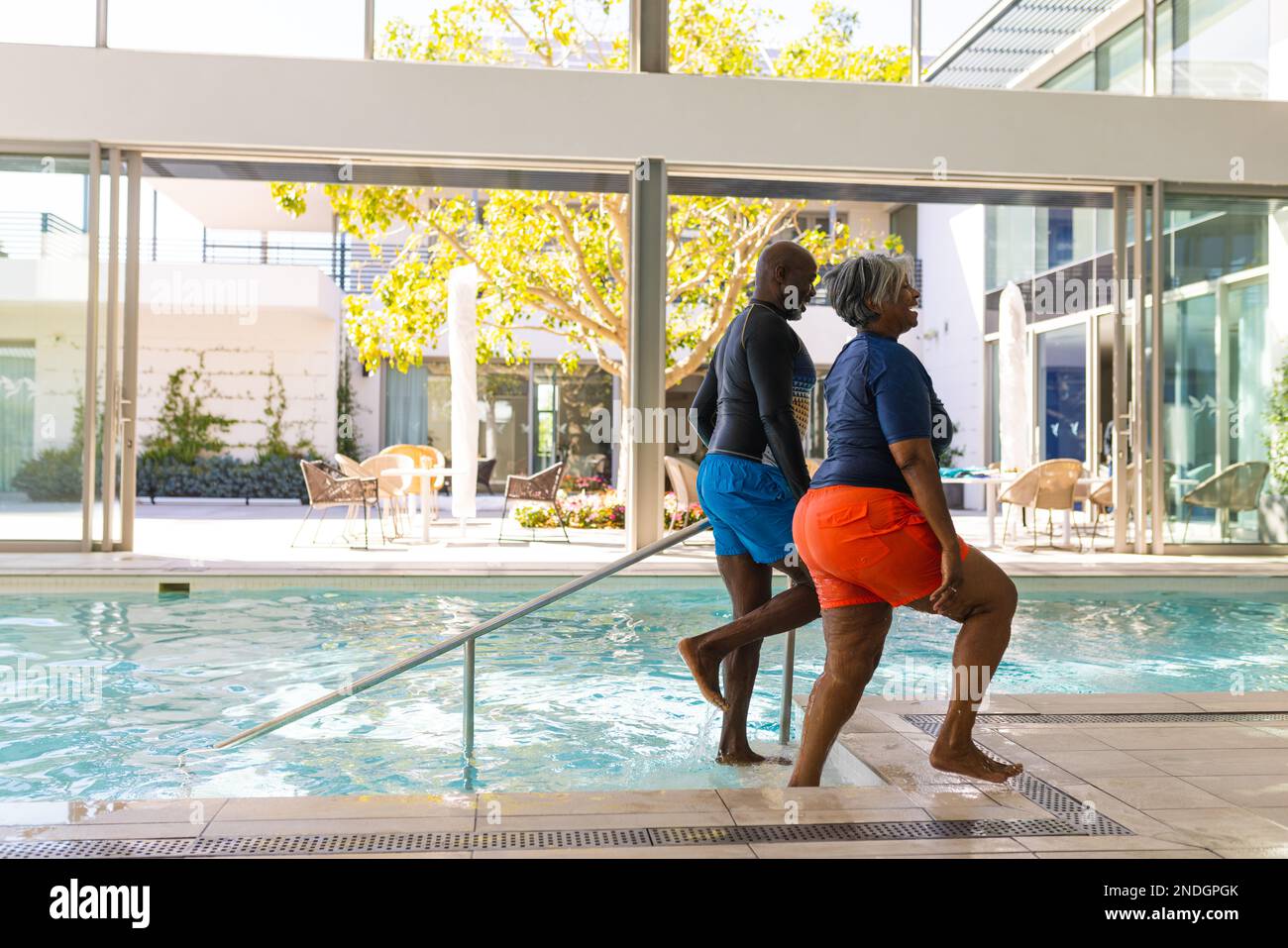 Una coppia afroamericana che sale le scale uscendo dalla piscina. stile di vita e concetto di vita senior in pensione Foto Stock