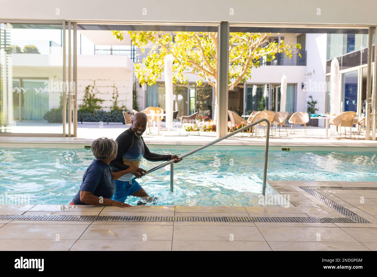 Una coppia afroamericana che sale le scale uscendo dalla piscina. stile di vita e concetto di vita senior in pensione Foto Stock