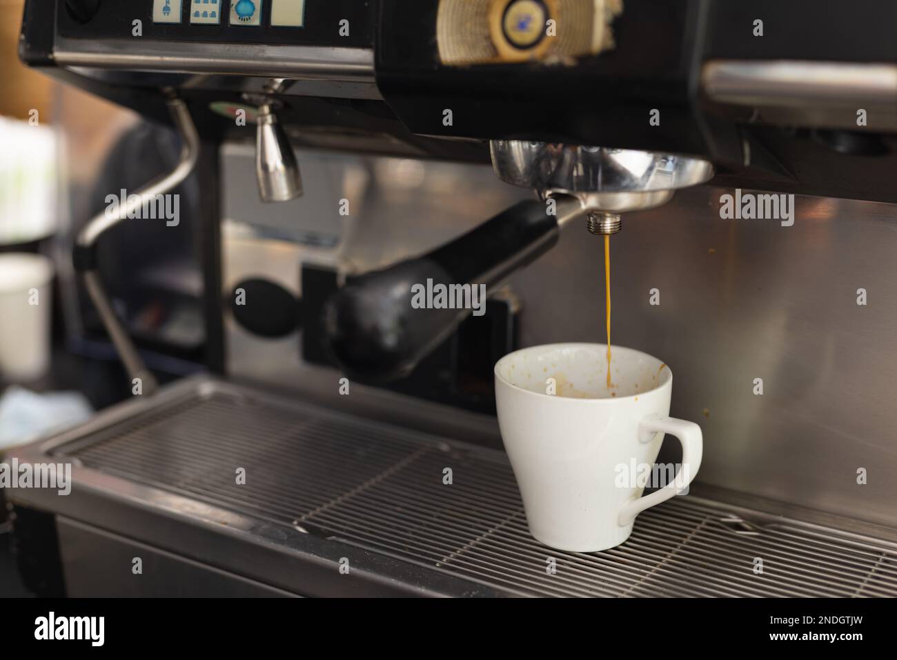 Primo piano della tazza di caffè dalla macchina per il caffè nel caffè. Caffè, tempo libero e concetto di città. Foto Stock