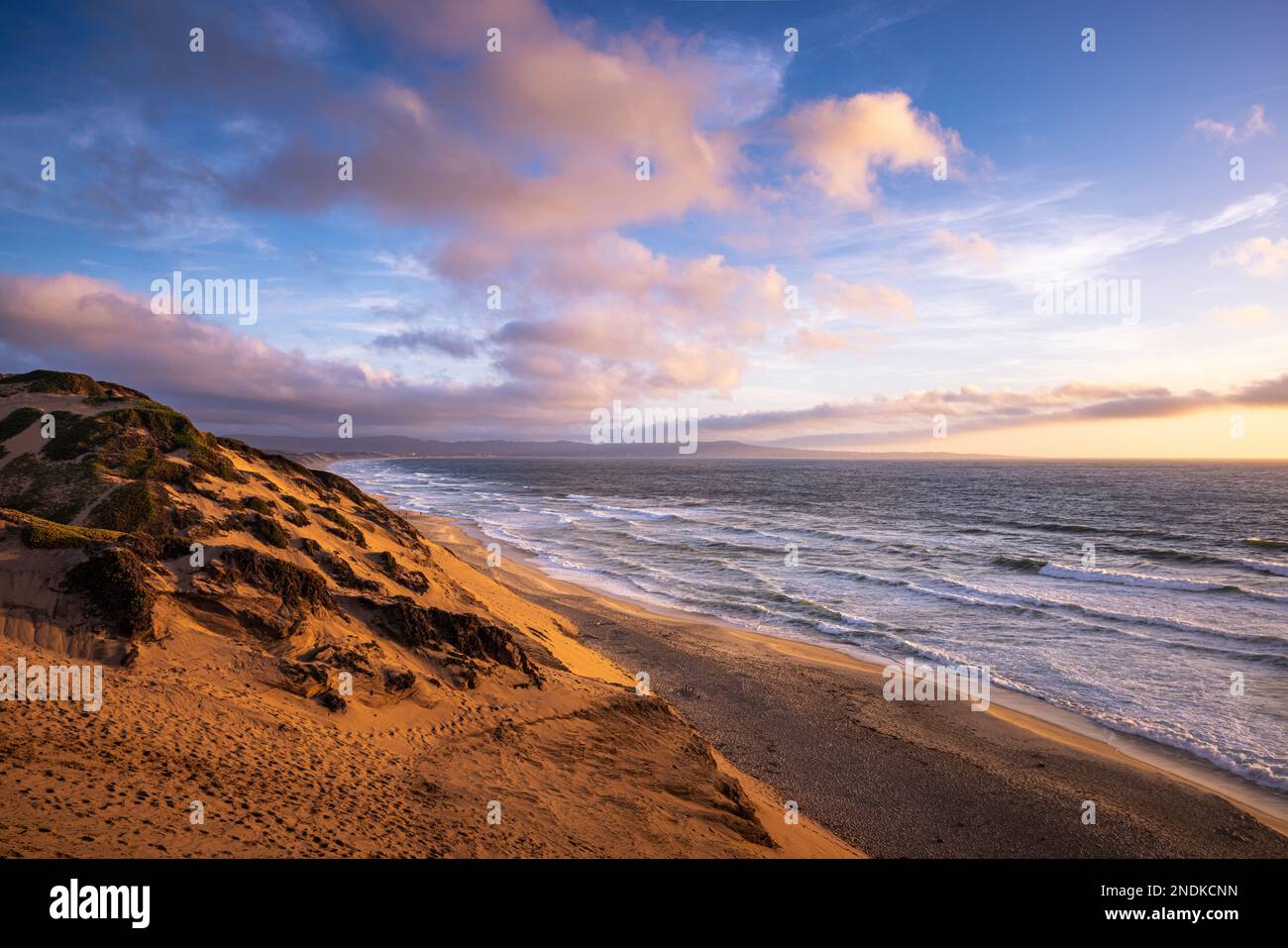 Un tramonto dopo una tempesta dalle dune di sabbia di Marina state Beach in California Foto Stock
