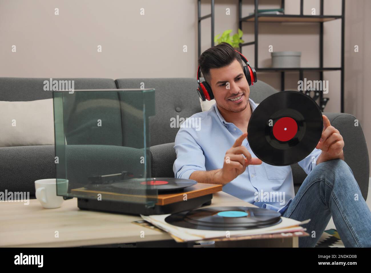 Un uomo felice che ascolta la musica con il giradischi a casa Foto Stock