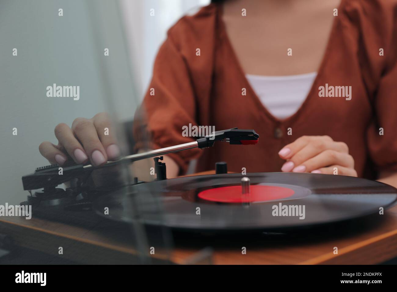 Donna che usa il giradischi a casa, vista in primo piano Foto Stock