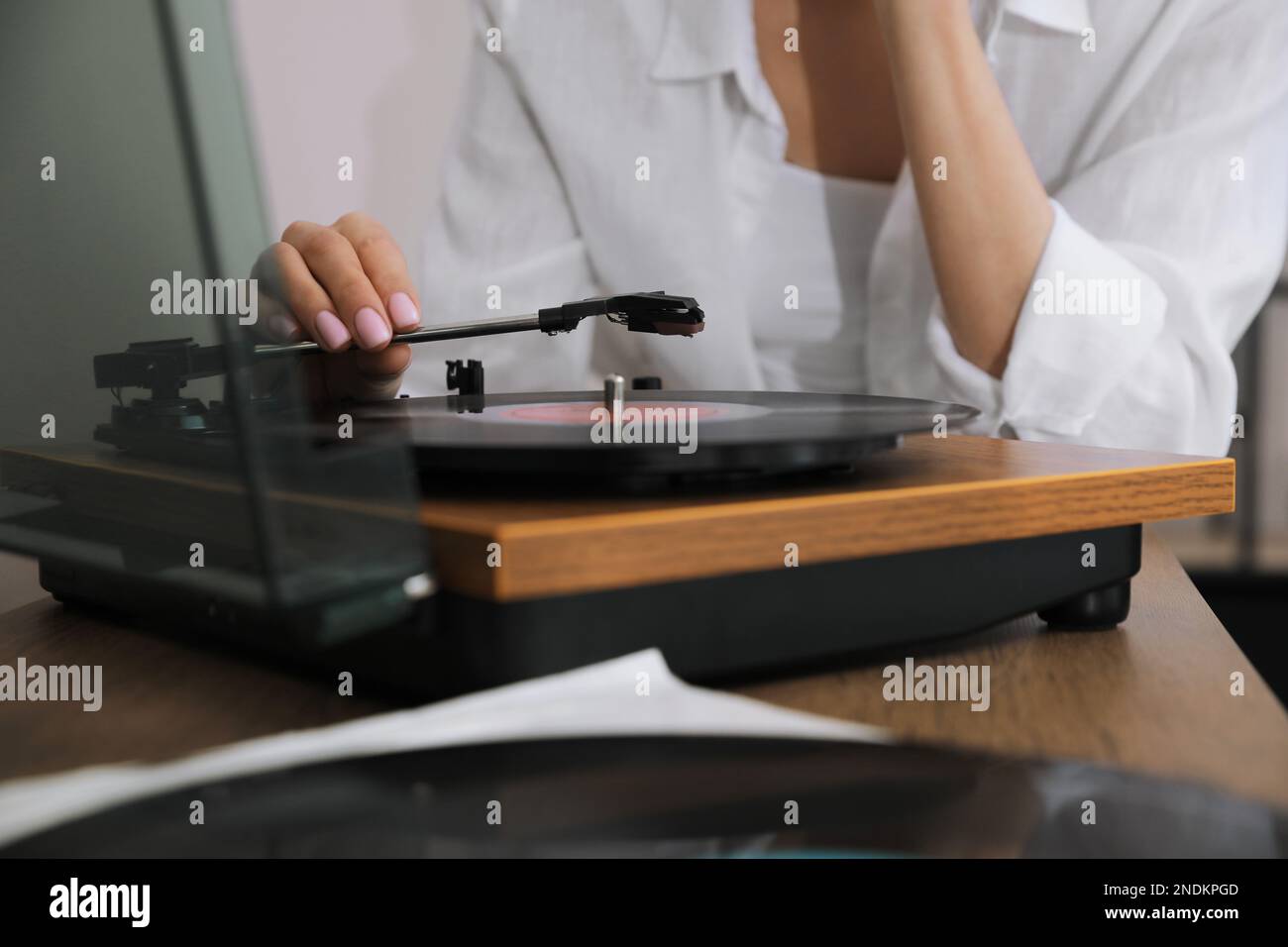 Donna che usa il giradischi a casa, vista in primo piano Foto Stock