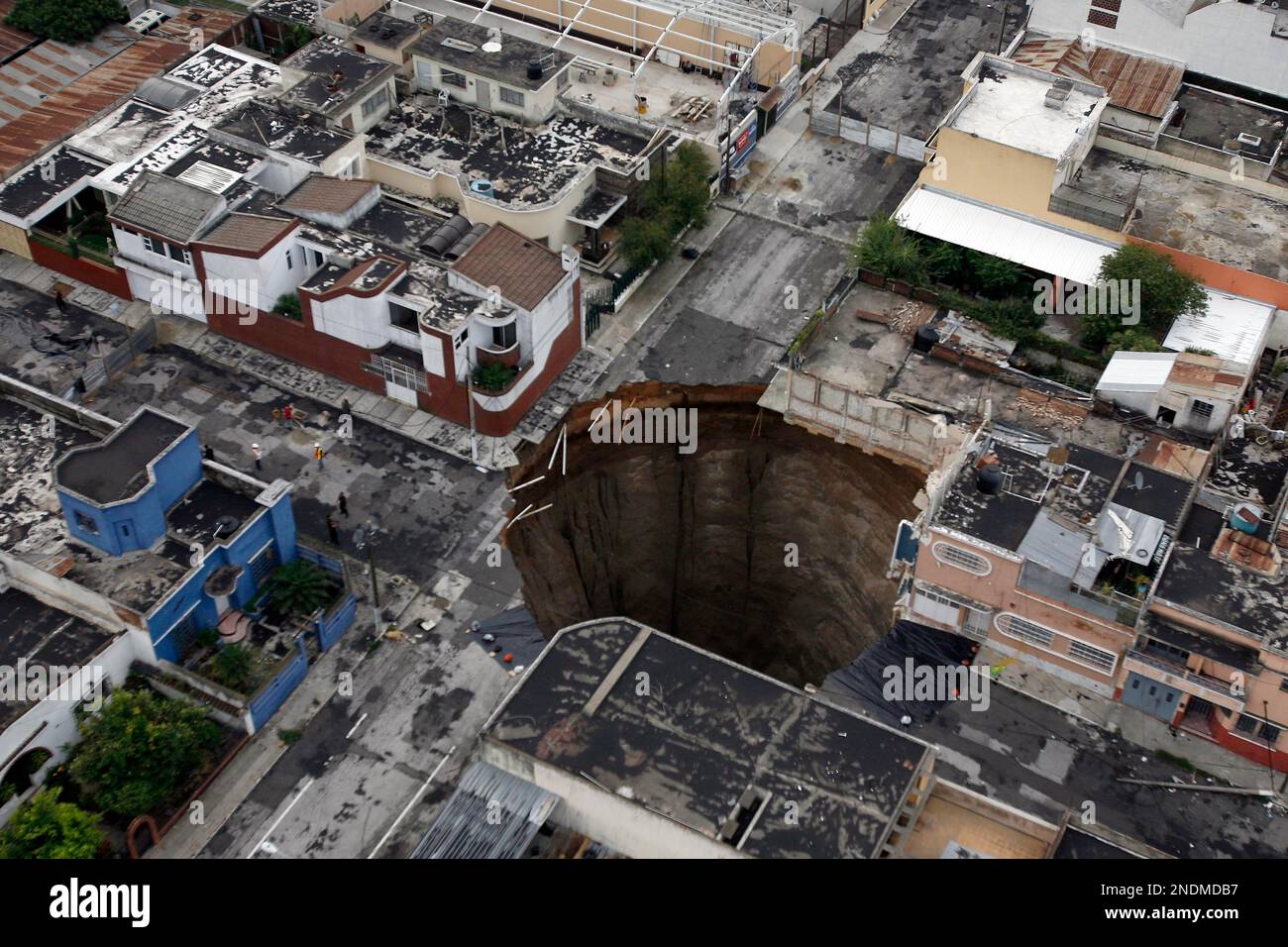 A sinkhole covers a street intersection in downtown Guatemala City, Wednesday, June 2, 2010. Authorities blamed heavy rains caused by tropical storm Agatha as the cause of the crater that swallowed a a three-story building but now say they will be conducting further studies to determine the cause. In April 2007 another giant sinkhole in the same area killed 3 people. (AP Photo/Moises Castillo) Foto Stock