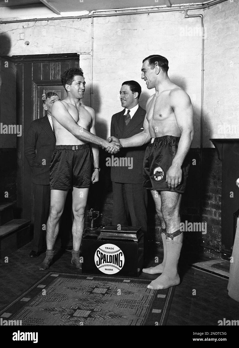 Italian heavyweight boxer Primo Carnera, right, shakes hands with opponent  South Africa's Donald Dinnie McCorkingdale, on April. 7, 1932. In the  center is boxing promoter Geff Dickson. (AP Photo/Staff/Len Puttnam Foto  stock -