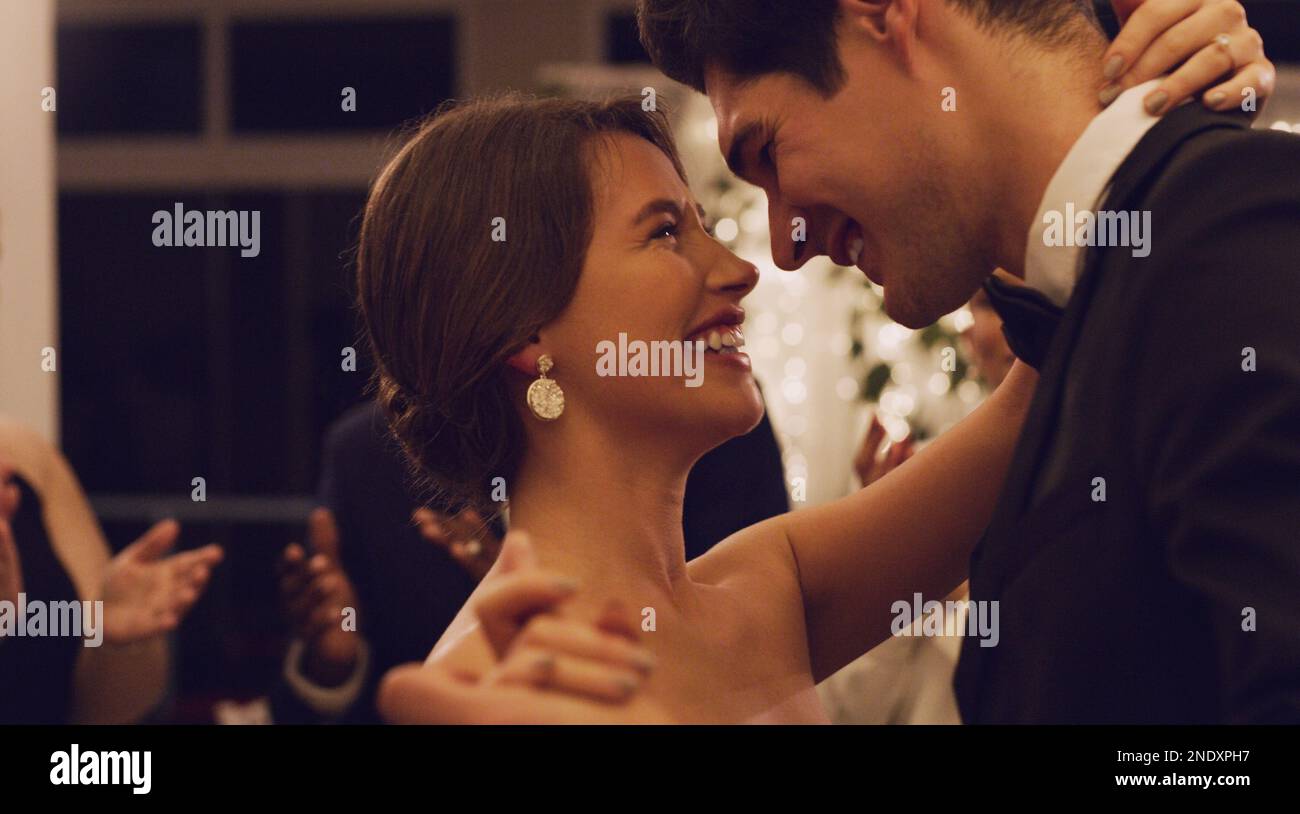 Credo che questa sia la mia parte preferita della reception. una giovane coppia affettuosa che ballava lentamente con i loro ospiti sullo sfondo Foto Stock