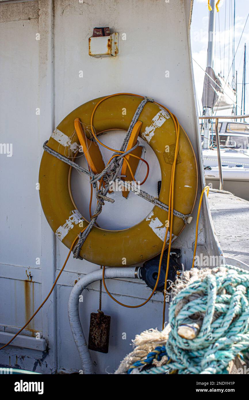 Un colpo verticale di una salvabuoy appesa su una parete di una barca su un porto in Australia Foto Stock