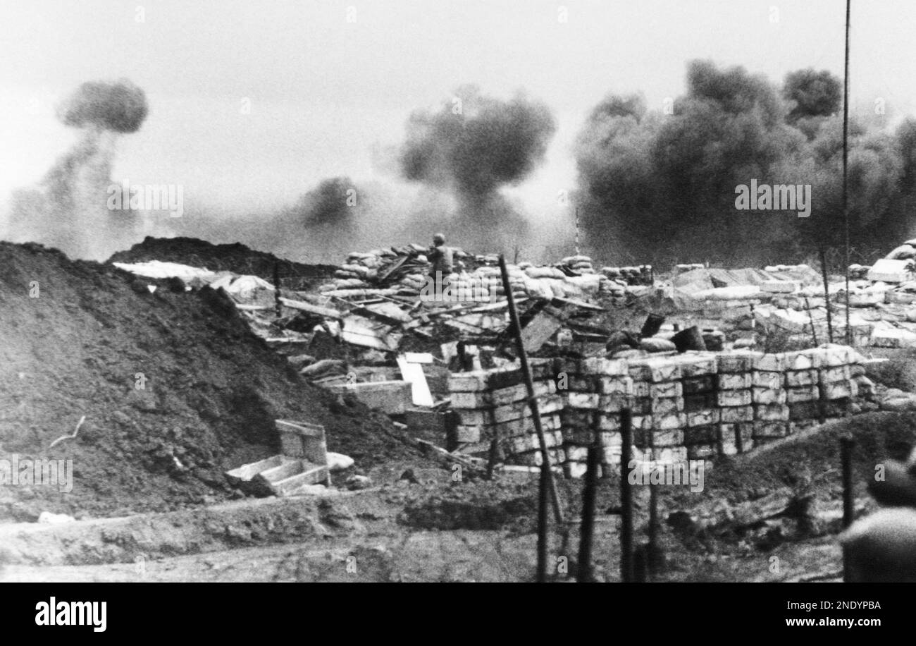 A U.S. marine, center, stands atop his post, a sandbagged bunker, as he ...